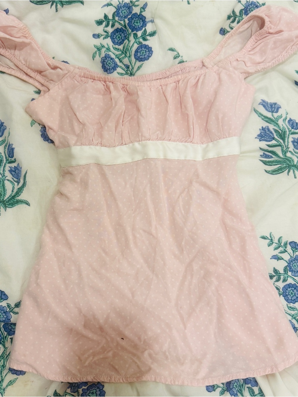 This Hollister babydoll top features a soft pink polka-dot pattern and a white